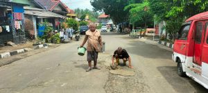 Terjadi Laka lantas Akibat Jalan Berlobang, Warga Leuwi Kaung Tambal Jalan di Jl Ir H Juanda Secara Swadaya